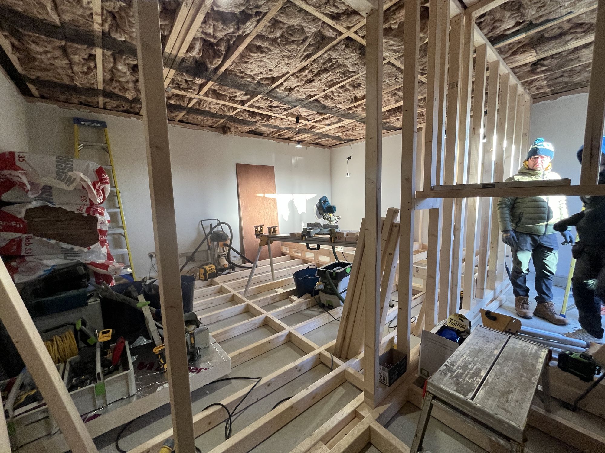 The raised floor framing going in to lift the back row, timber studwork through the room