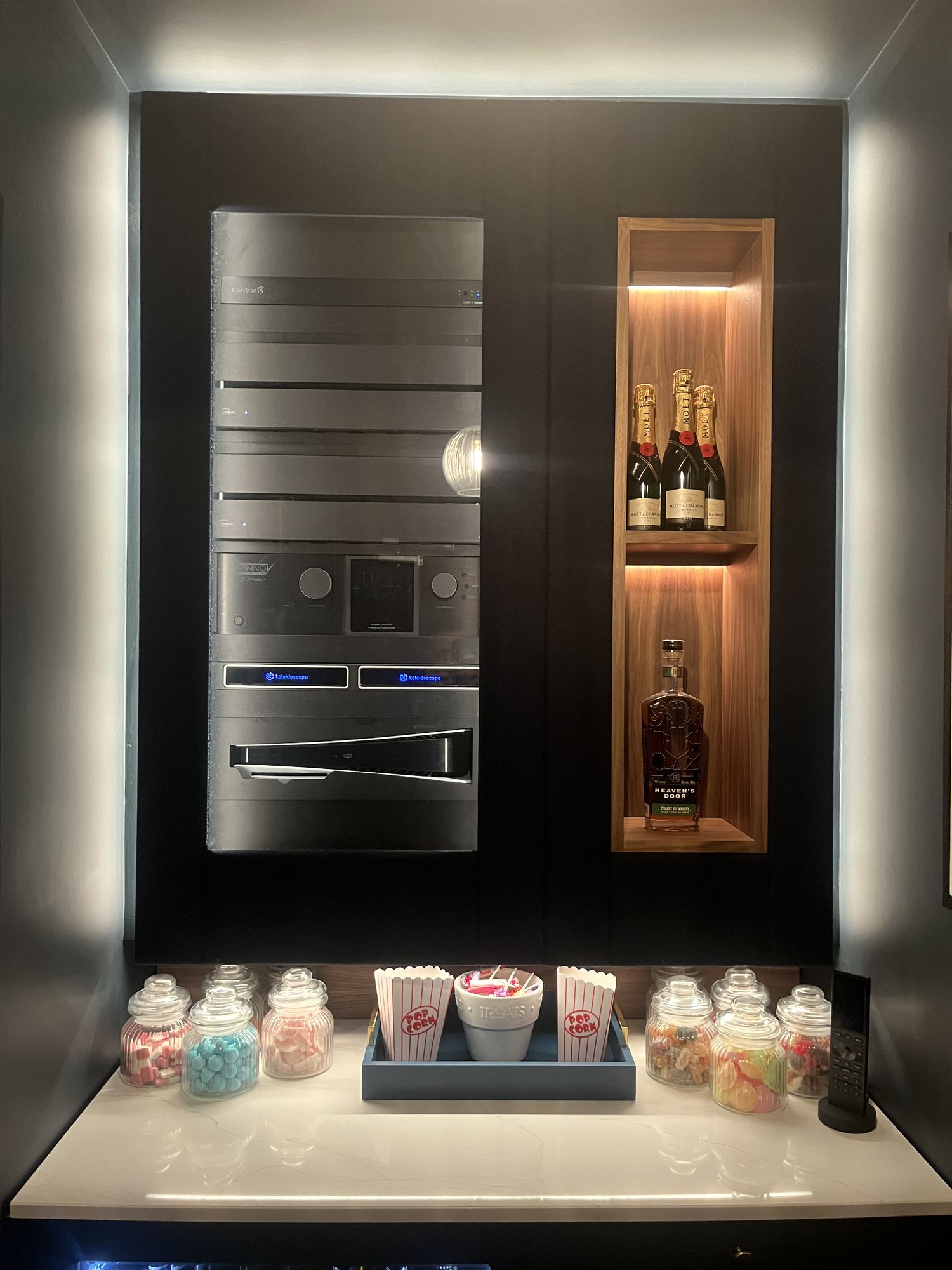 The concession counter: a backlit walnut niche with champagne and whiskey above jars of sweets and popcorn