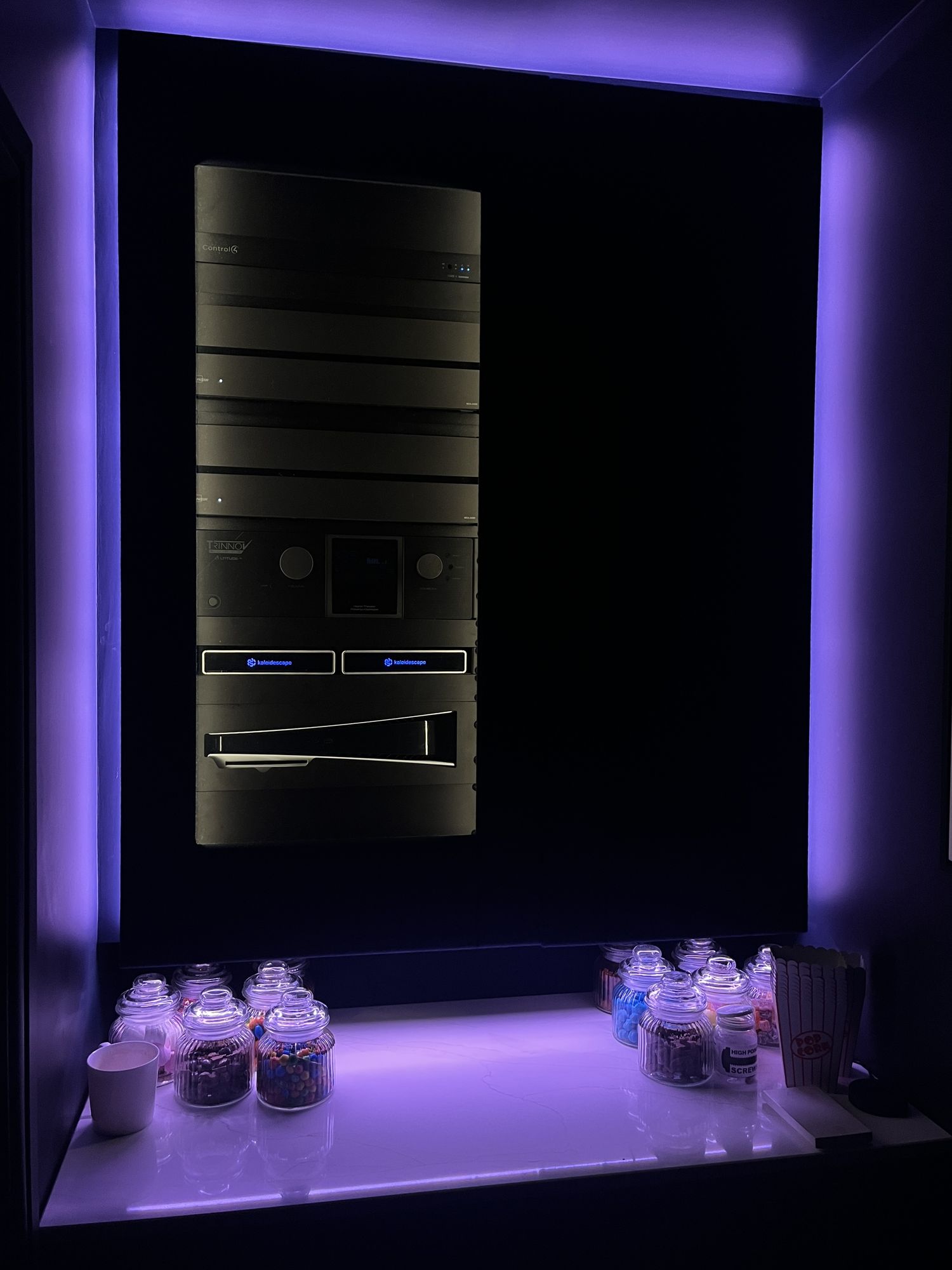The equipment rack lit behind the concession wall, with the candy counter below