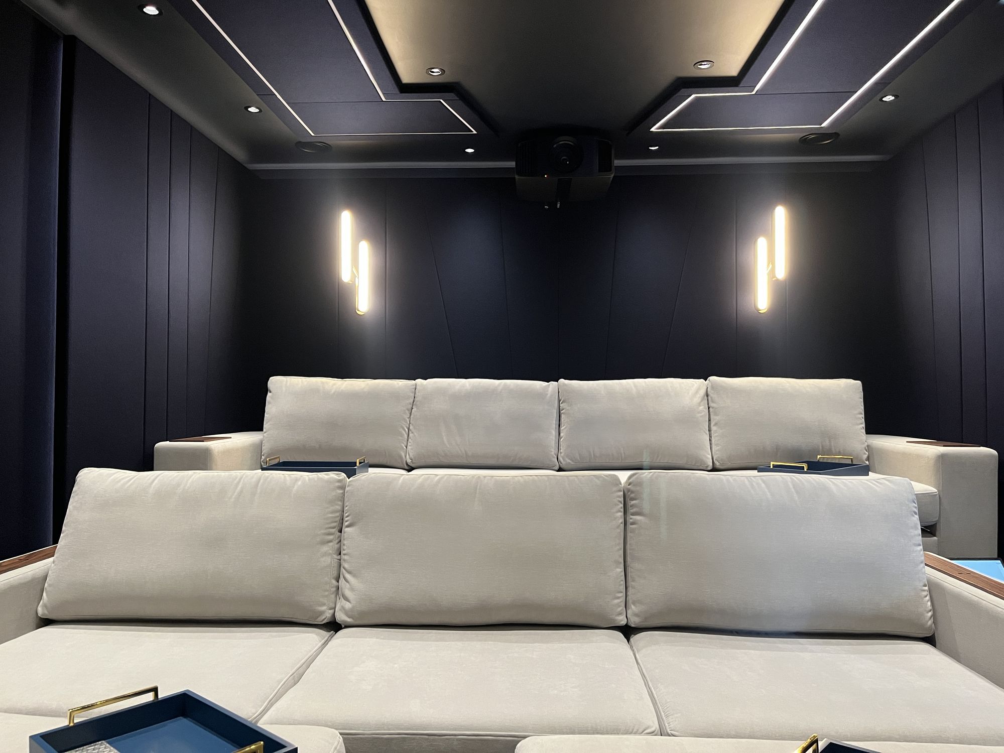 The pale upholstered seating below the brass sconces, pillows and cushions in soft velvet