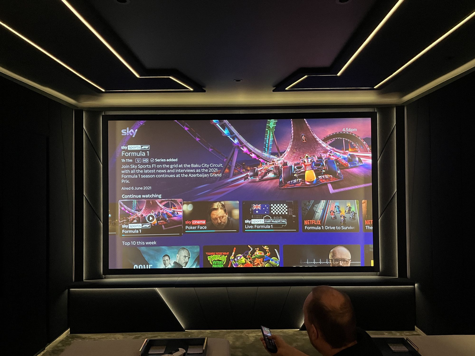 Formula 1 playing across the full cinema screen, the room dark around it